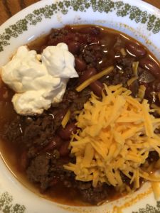 Chili topped with sour cream and cheddar cheese